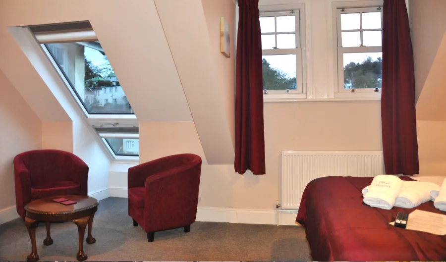 King room with red armchairs and roof window