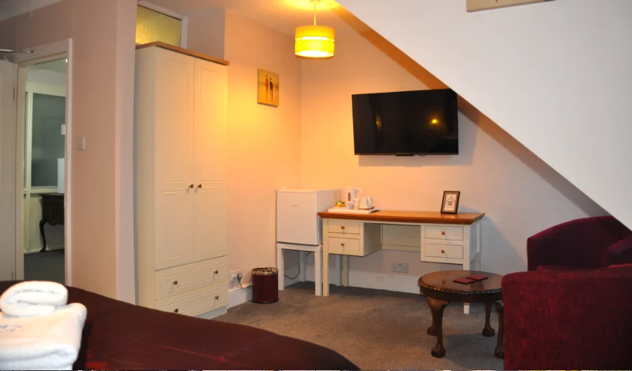 King room with desk, TV and armchairs