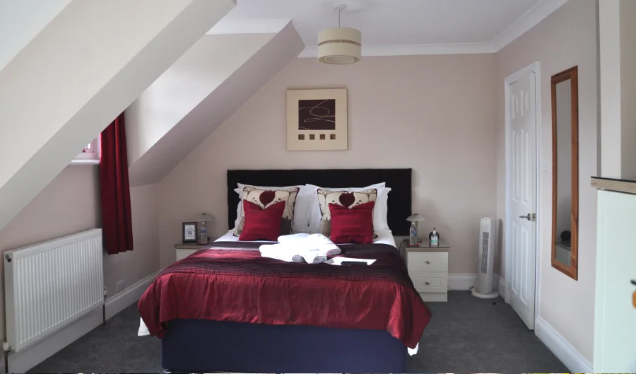 King room with red cushions under the eaves